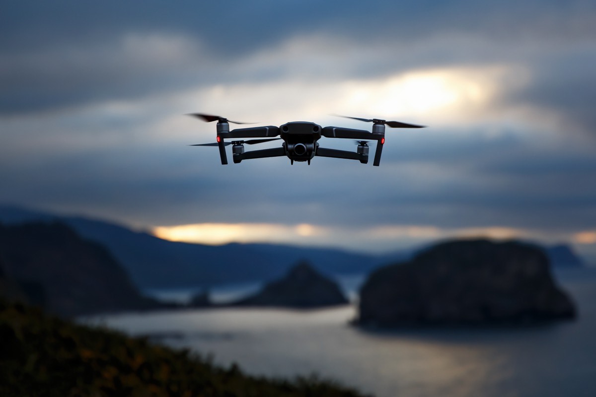 Commercial drone flying over a landscape at dusk